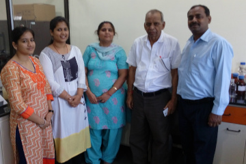 five persons in a laboratory smiling at the camera