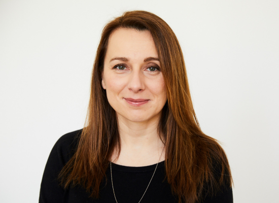 woman with long, brown hair softly smiling into camera